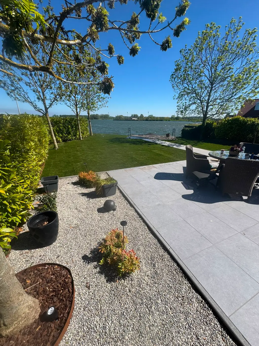Aanplanting grindborder heesters waterkant — tuinaanleg door Homeservices in regio Voorne aan Zee